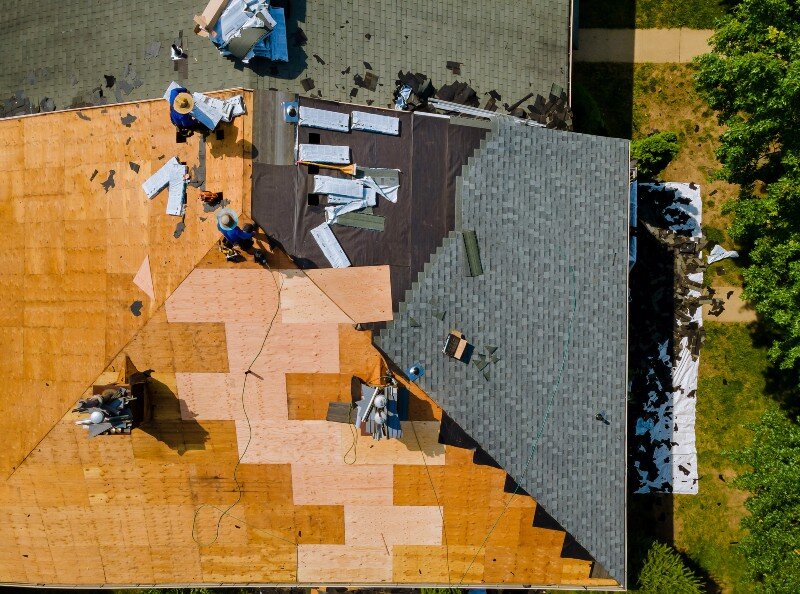 Workers fix a damaged roof in Houston, TX.
