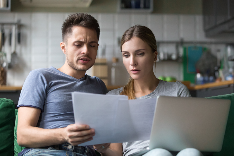 A young couple getting all their documentation ready to sell their house with a mortgage