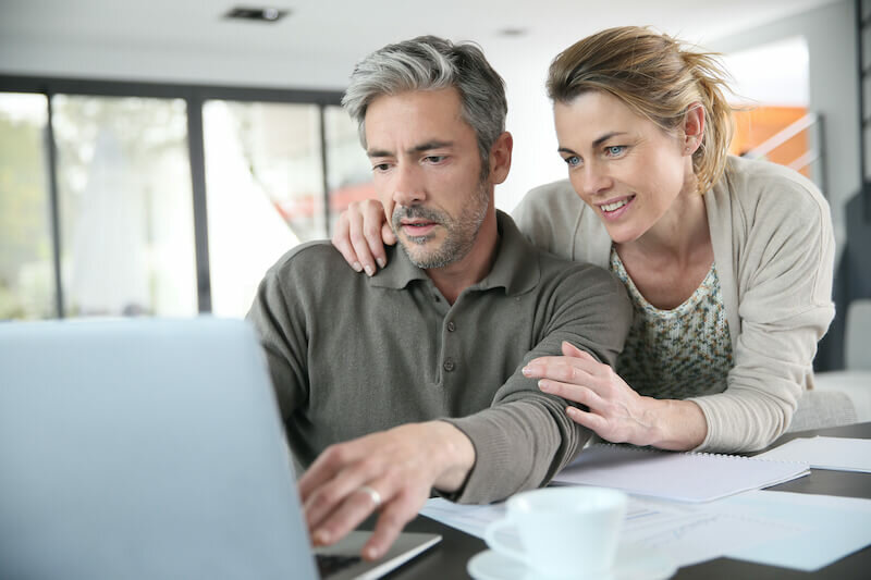 couple researching their homes market value in the internet